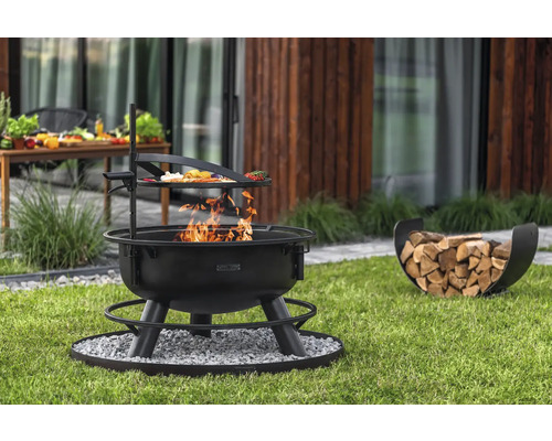 Vuurplaats met grillrooster en houtmand op gazon