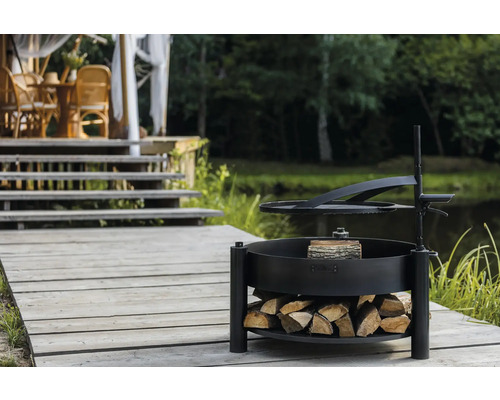 Barbecueplaats met houtopslag op een houten terras in de buurt van een vijver.