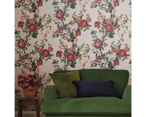 Woonkamer met bloemenbehang, bank en potplant.