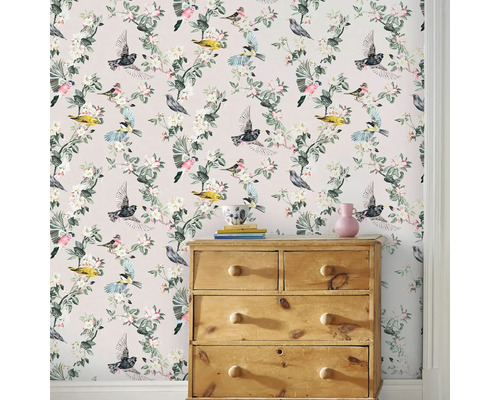 Scene met een commode voor een behang met een vogel- en bloemmotief