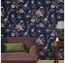 Woonkamer met bloemenbehang, fauteuil en tafellamp
