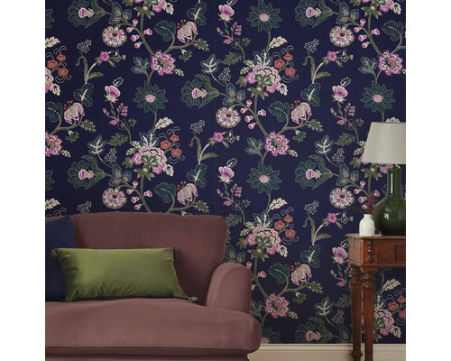 Woonkamer met bloemenbehang, fauteuil en tafellamp