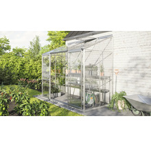 Kweekkas met planken en tuingereedschap in de tuin