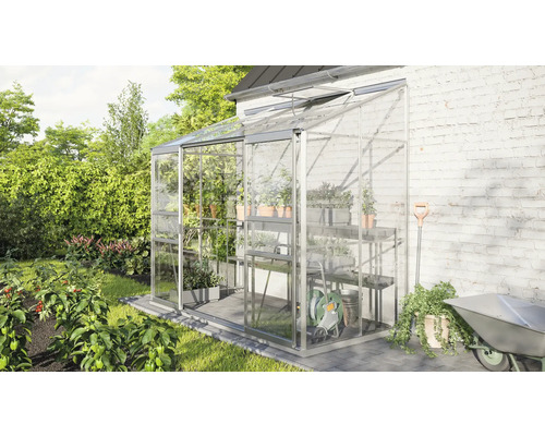 Kweekkas met planken en tuingereedschap in de tuin