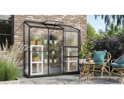 Kas met planken en planten naast een zithoek op het terras