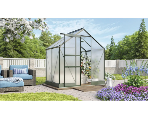 Kas in de tuin met planten en tuinmeubelen