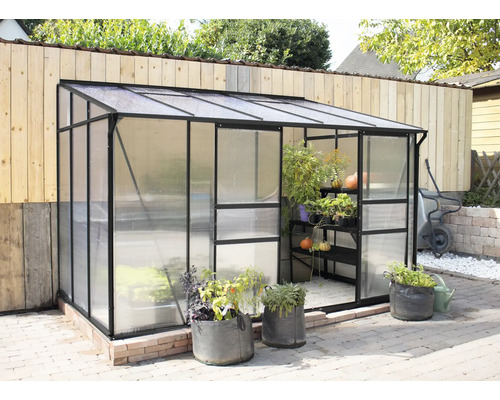 Tuinkas met planten en tuingereedschap buitenshuis.
