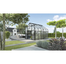 Tuinkas in een tuin met een huis op de achtergrond.