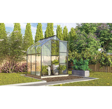 Glazen en metalen serre in de tuin met planten