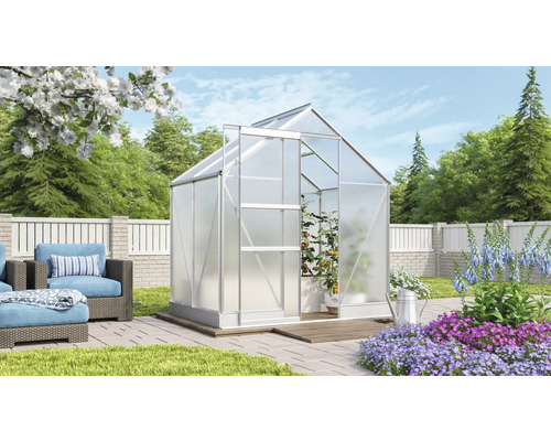 Tuin met kas en openstaande deur