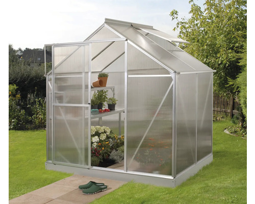 Tuinkas met planten en schappen in de tuin