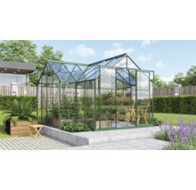 Kas in de tuin met planten en tuinmeubelen.
