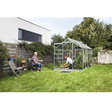 Tuinkas in een tuin met twee vrouwen, één aan het tuinieren, de ander zittend.