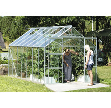 Kas met planten en twee personen in de tuin