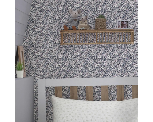 Kameropstelling met bloemenbehang, een plank met decoratie en een bed.