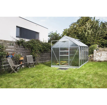 Kas in tuin met gazon en tuinmeubelen