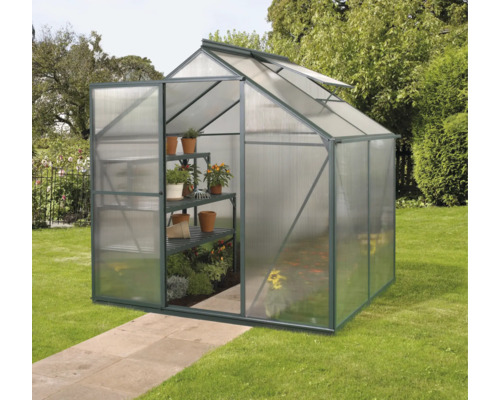 Kas met rekken en planten in de tuin