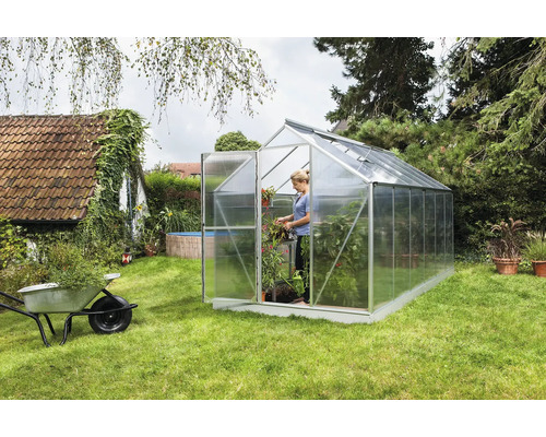 Kas in tuin met vrouw en planten