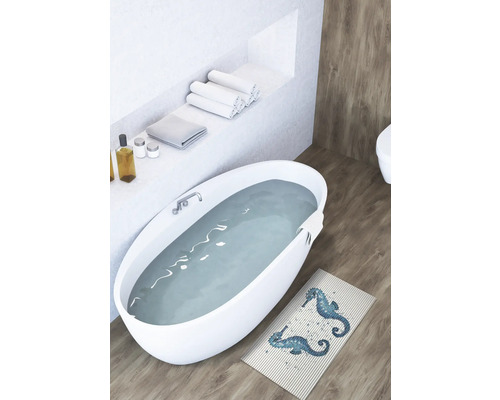 Lichte badkamer met vrijstaand bad, handdoeken en badmat