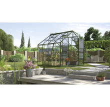 Kas in de tuin met planten en tuinmeubelen op het terras.