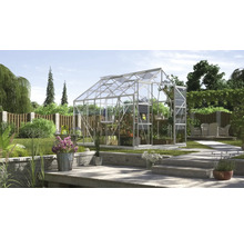 Kas in de tuin met planten en tuinmeubelen