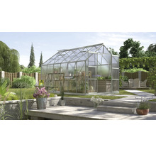 Kas in de tuin met planten en tuingereedschap.