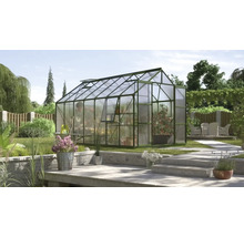 Kas in de tuin met plantenrekken en tuingereedschap.