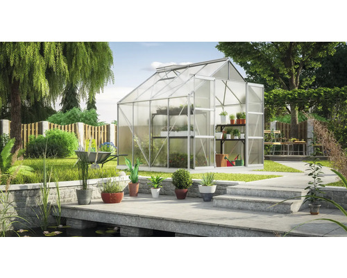 Kas in de tuin met planten en tuingereedschap.