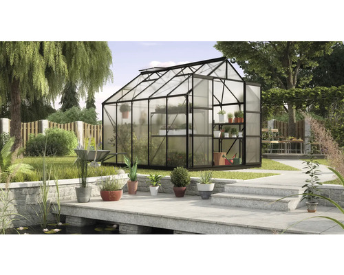 Kas met plantenrekken in een tuin met een vijver