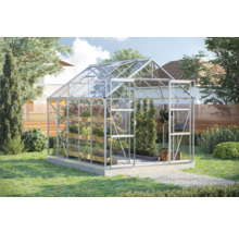 Glazen en aluminium kas met planten in de tuin