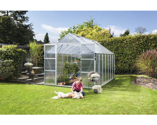 Tuinkas in tuin met spelend kind en hond op het gazon.