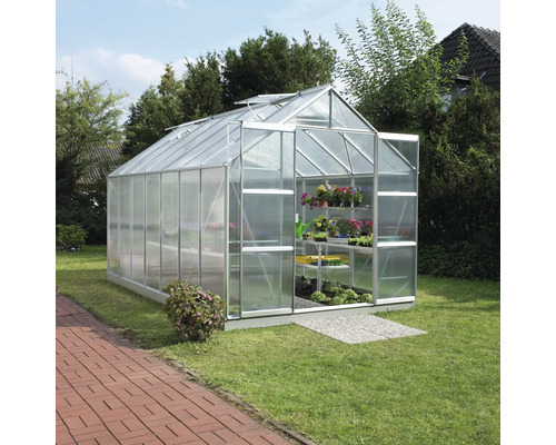 Kas in de tuin met plantenrekken