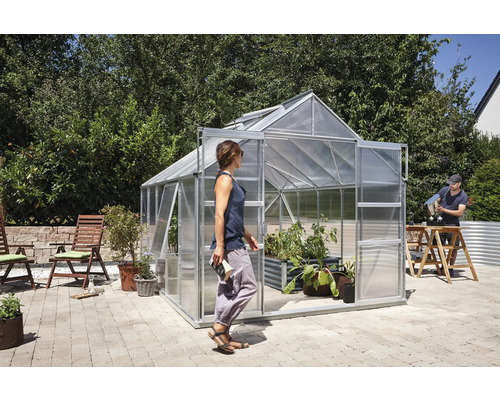 Kas met planten en personen in de tuin
