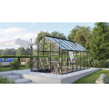 Kas met glazen wanden en schappen in de tuin.