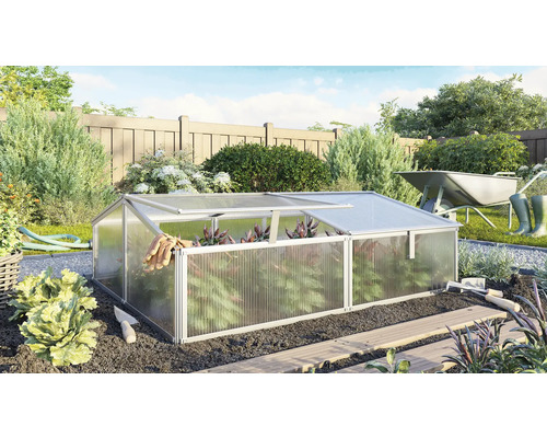 Kas in tuin met tuingereedschap en kruiwagen