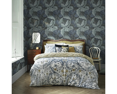 Slaapkamer met behang en beddengoed met motief voor een harmonieuze sfeer.
