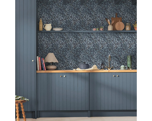 Keukenscène met blauw behang met bladerpatroon, blauwe kasten en houten planken