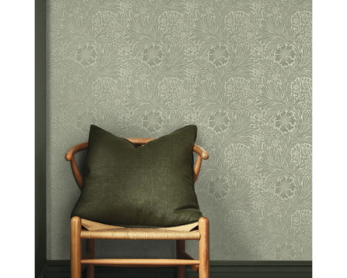 Stoel met kussen voor een muur met een bloemig behangpatroon