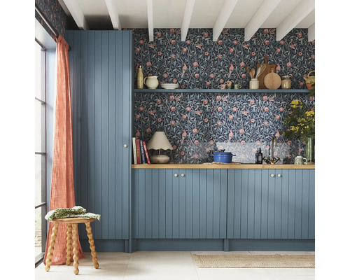 Keuken met blauwe kasten, bloemenbehang en houten details voor een gezellige uitstraling