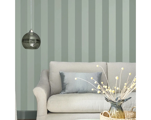 Woonkamer met gestreept behang, bank, sierkussen en hanglamp