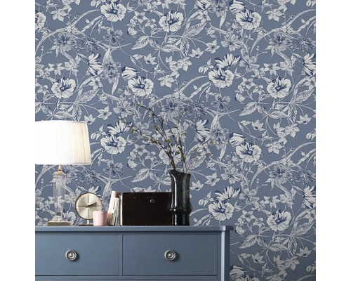 Decoratieve kamer met bloemig vliesbehang op de muur, dressoir, lamp en decoraties.