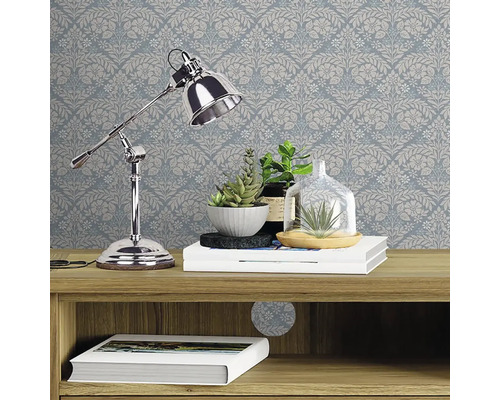 Decoratieve muur met bloemenbehang, ingericht met een bureaulamp, planten en boeken