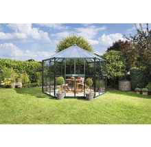 Achtkantig tuinhuis van glas en metaal in de tuin met tafel en stoelen