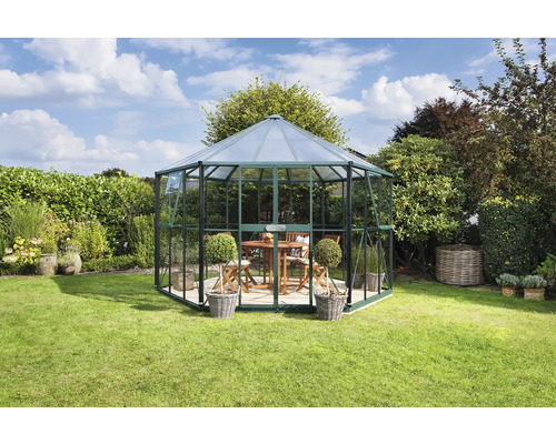 Achtkantig tuinhuis van glas en metaal in de tuin met tafel en stoelen