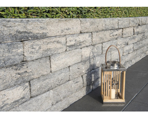 Grijze tuinmuur met decoratieve lantaarn