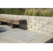 Buitenkant met muur van stenen blokken, bank van hout en stenen vloerplaten