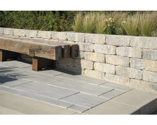 Buitenkant met muur van stenen blokken, bank van hout en stenen vloerplaten