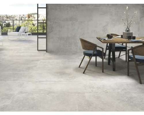 Lichte ruimte met stenen tegels, eettafel en zitplaatsen buiten