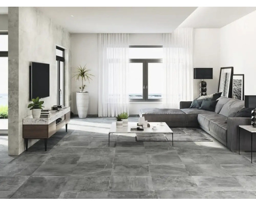 Lichte woonkamer met grijze tegels, hoekbank en televisie