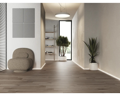 Licht interieur met akoestische panelen, fauteuil en potplanten op een houten vloer.